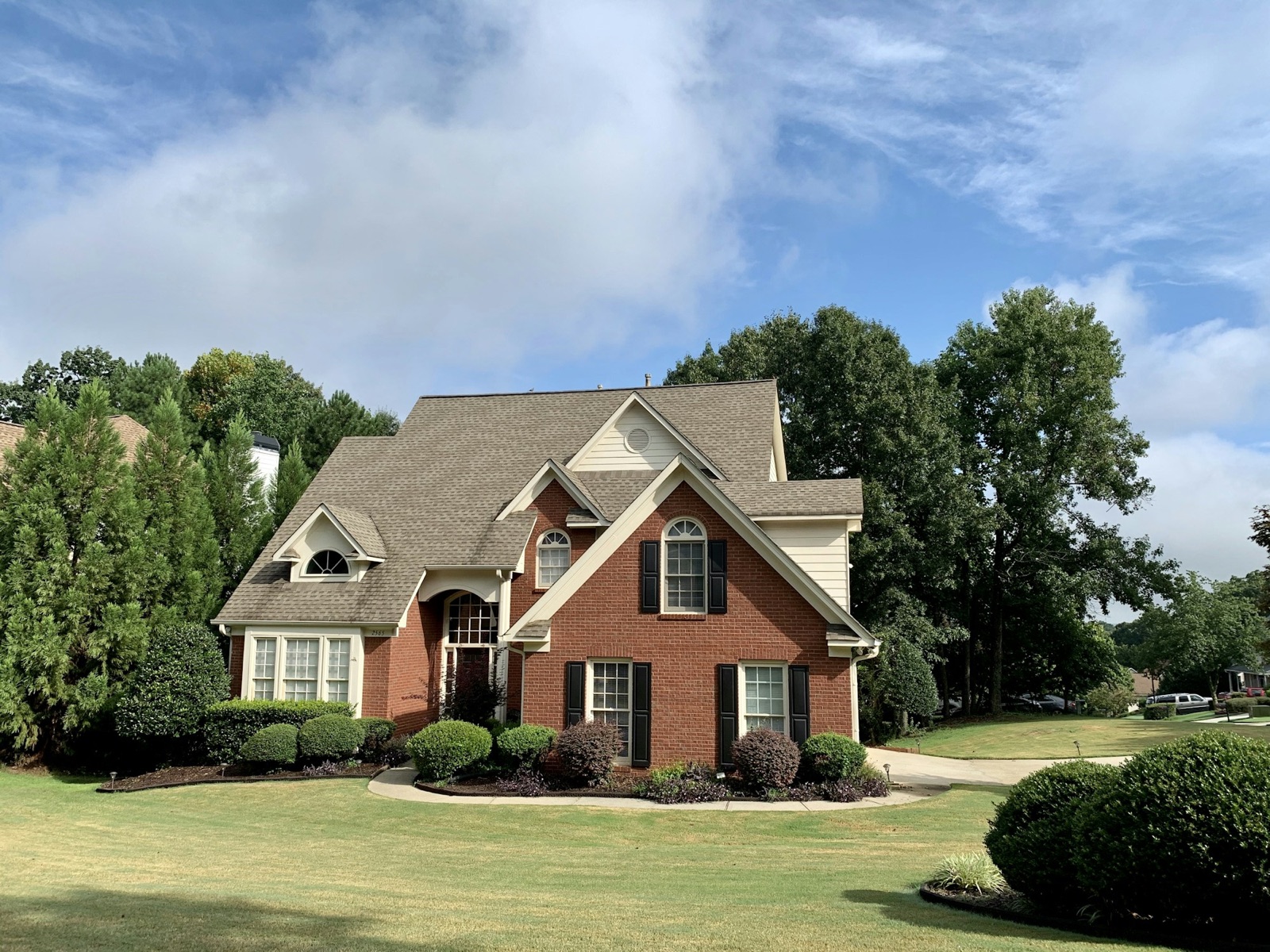 Brick two-story home on a summer day